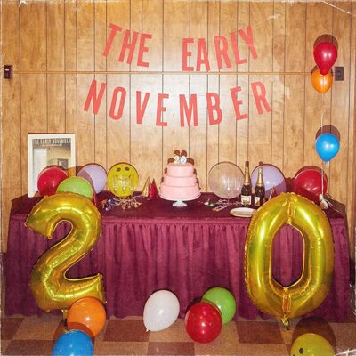 The Early November - 20. A table is laid out for a party with a band name banner and ballons in the shape of a 2 and 0.
