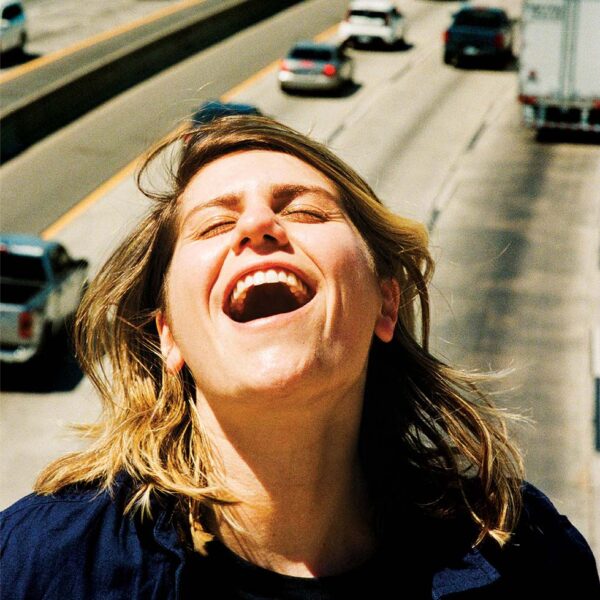 The singer-songwriter Alex Lahey singing above a busy highway.