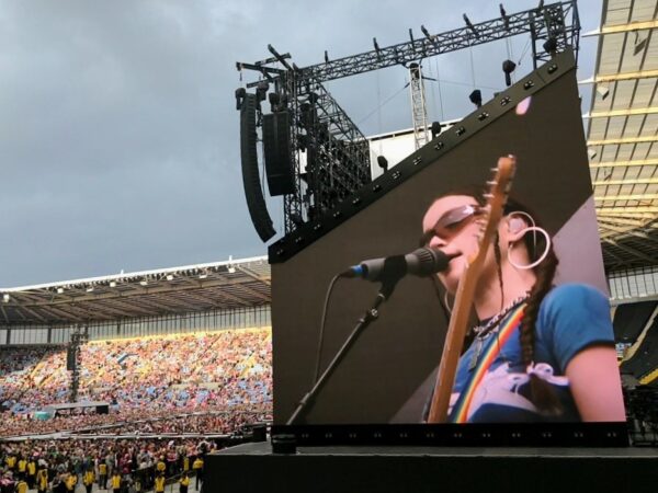 Wet Leg live in Coventry. Rhian is shown on the big screen with thousands of music lovers filling the stadium.