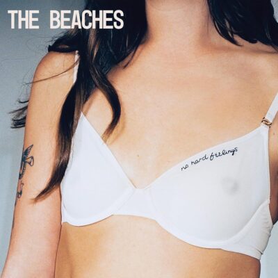Beaches - No Hard Feelings. A closely cropped picture of a woman that shows the top of her right arm, her chest, and neck. She has a tattoo on her arm and is wearing a white bra with the album title.